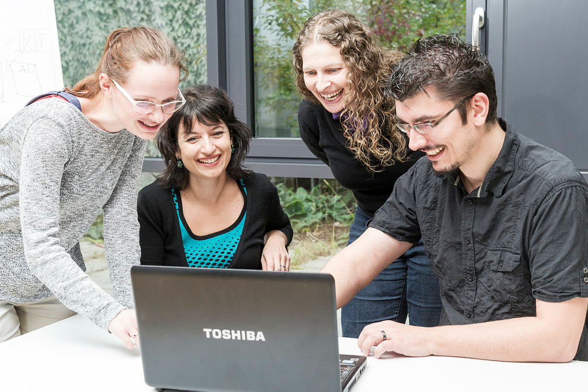 Junge Menschen schauen gemeinsam auf Laptop