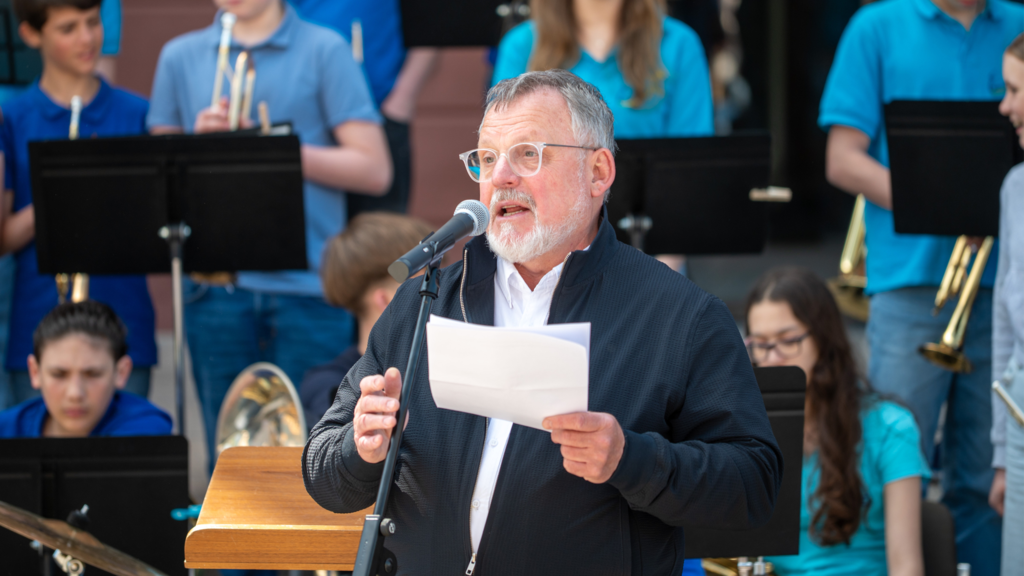 Christof Weinhardt auf einer Bühne mit einem Mikrofon