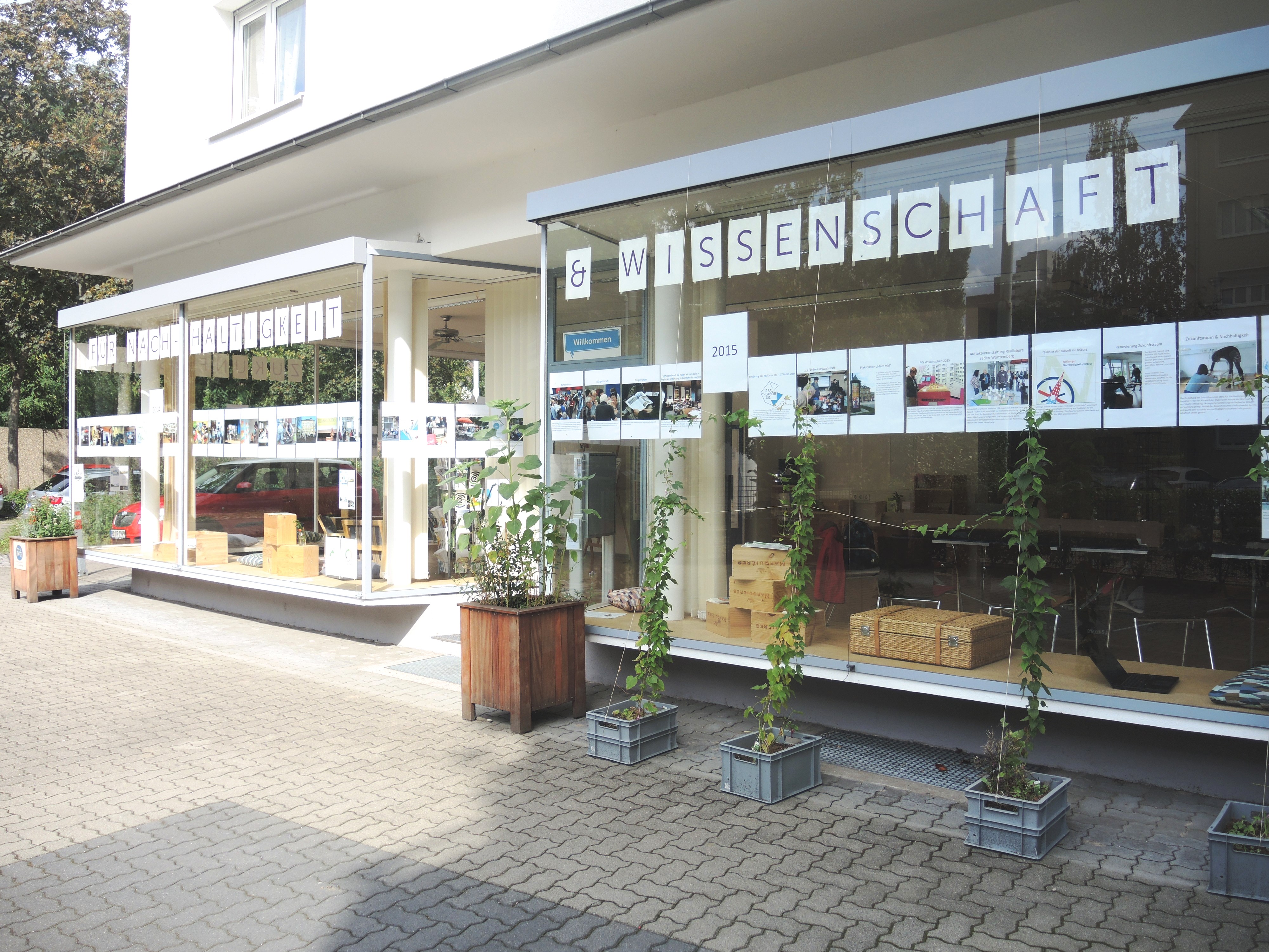 Der Zukunftsraum des Quartier Zukunft. Man sieht große Schaufenster, auf denen steht: Für Nachhaltigkeit & Wissenschaft.