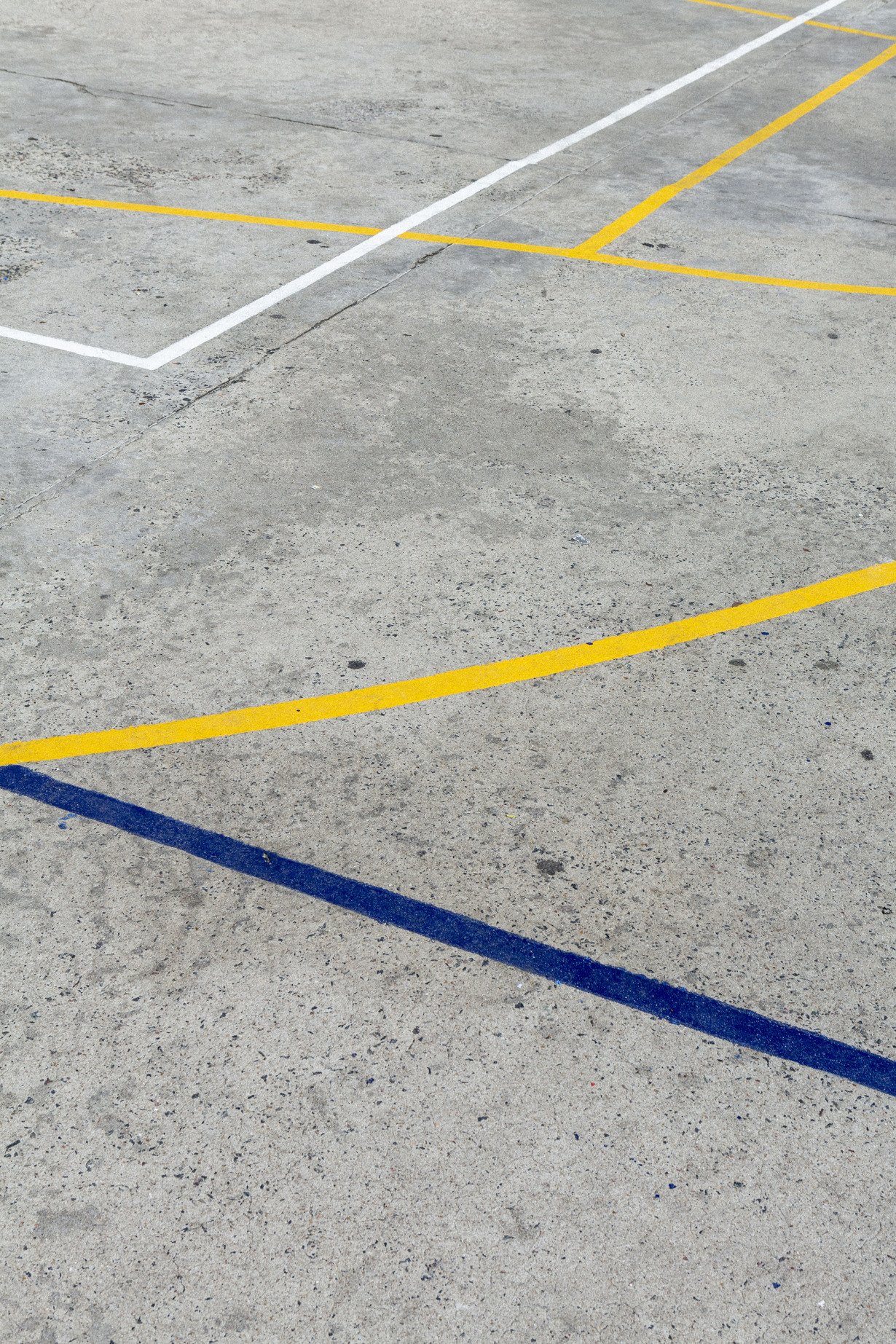 Nahaufnahme eines Beton-Spielfelds mit bunten Linien.