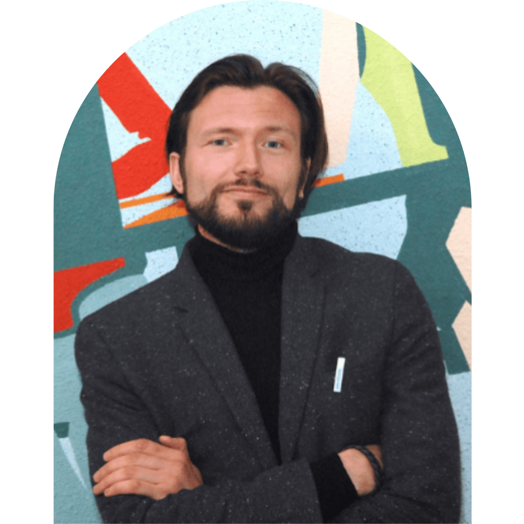 Bild von Ivan Savin. Er verschränkt die Arme und stehlt vor einer bunten Wand.